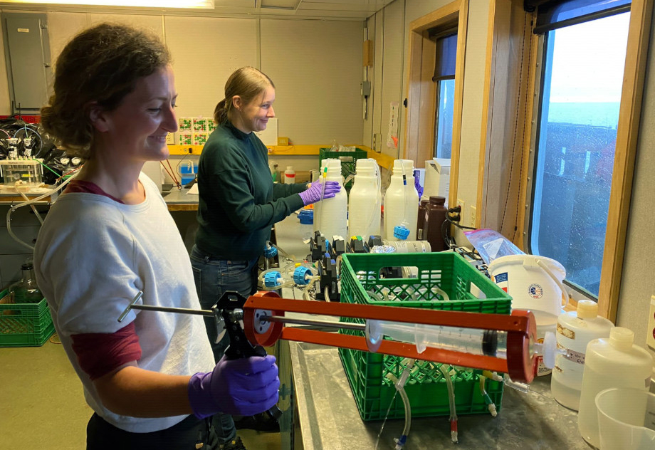 A syringe in a caulking gun doubles as a filtration device as Josephine Rapp (left) and Susanne Kraemer process the microbial samples. (Photo: Nicolas Sylvestre)