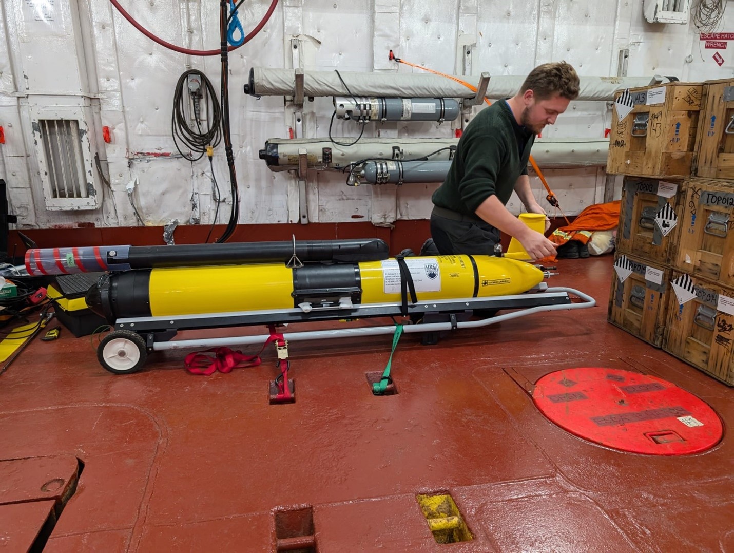 Seth Fleming-Alho in the helicopter hangar preparing the glider for deployment (Photo by Mary-Louise Timmermans).