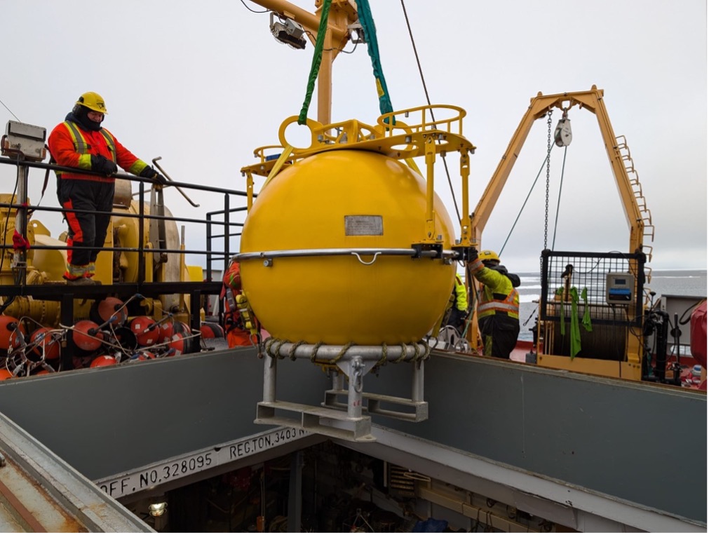 The top flotation sphere of mooring B is lifted out of the ship’s forward hold (Photo by Mary-Louise Timmermans)