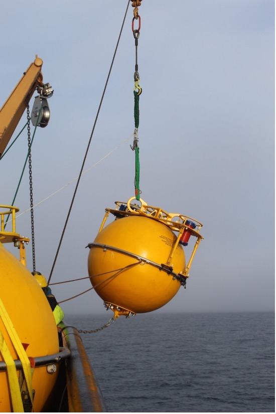 The mooring’s flotation sphere is lowered off the deck (Photo by Paul Macoun) 