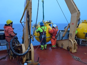 Nico Llanos and Bosun Rico Amamio guide the top sphere of Mooring D onboard (Photo by Mary-Louise Timmermans)