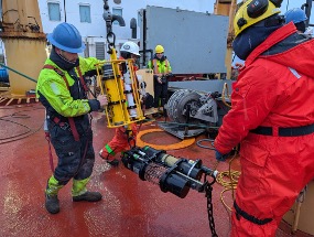 Nico Llanos and Jerome Sibley guide the CO2 and pH sensors aboard during the recovery of Mooring D (Photo by Mary-Louise Timmermans)