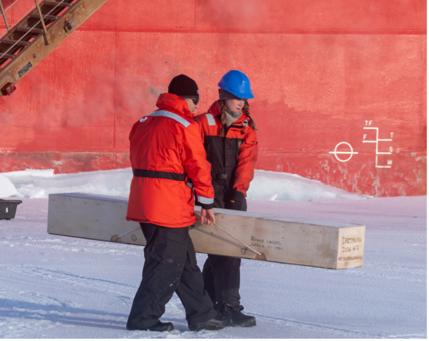 Chief Scientist Paul Macoun and Ashley Arroyo carrying the SIMB to its site (Photo by Gary Morgan)