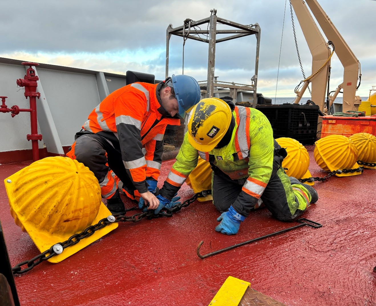 Photo 4: Tim McDonough (left) and deckhand Devon Fitzpatrick (right) disassembling a set of glass balls after their recovery from Mooring A. These balls sit around 2000 m deep and provide additional buoyancy for the mooring recovery. 