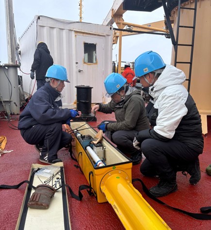 Photo 1: Shotaro Muraoka (left), Kazu Tateyama (middle), and Takuji Waseda (right) assembling the EM-31 sensor which will measure sea ice thickness along the cruise track. 