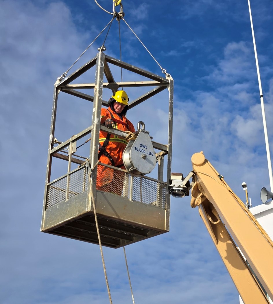 Deckhand Jerome Sibley hanging the block on the fore deck A-frame in preparation for upcoming mooring operations. 