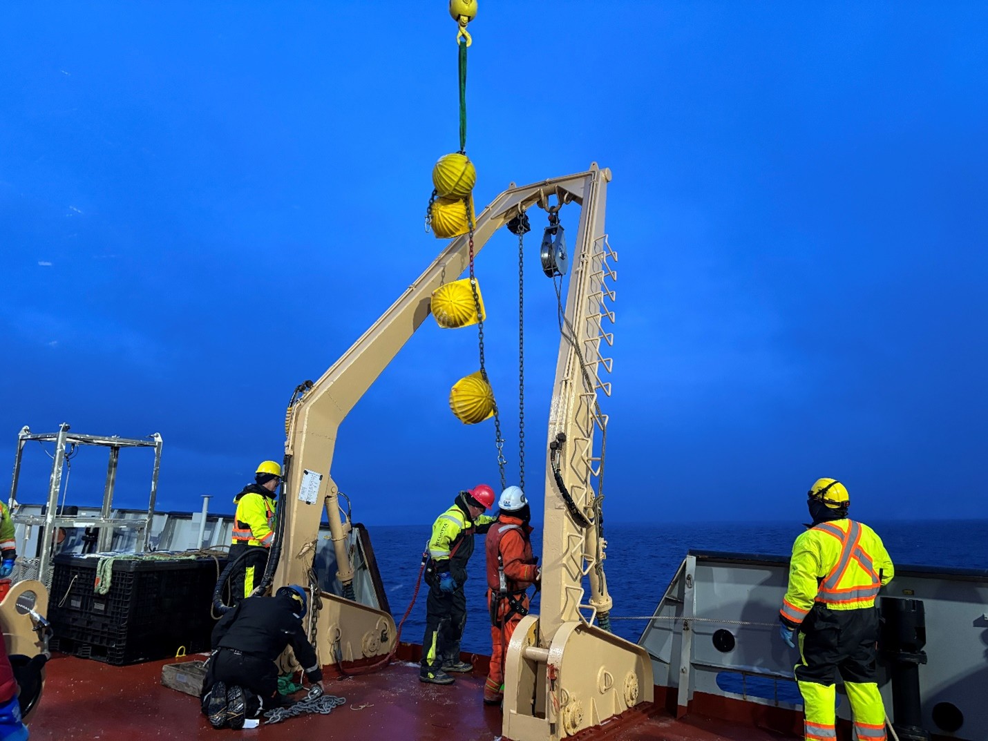 Photo 3: Jim Ryder and boatswain Rico Amamio attaching a set of glass balls (which provide additional buoyancy) to Mooring A’s wire. 