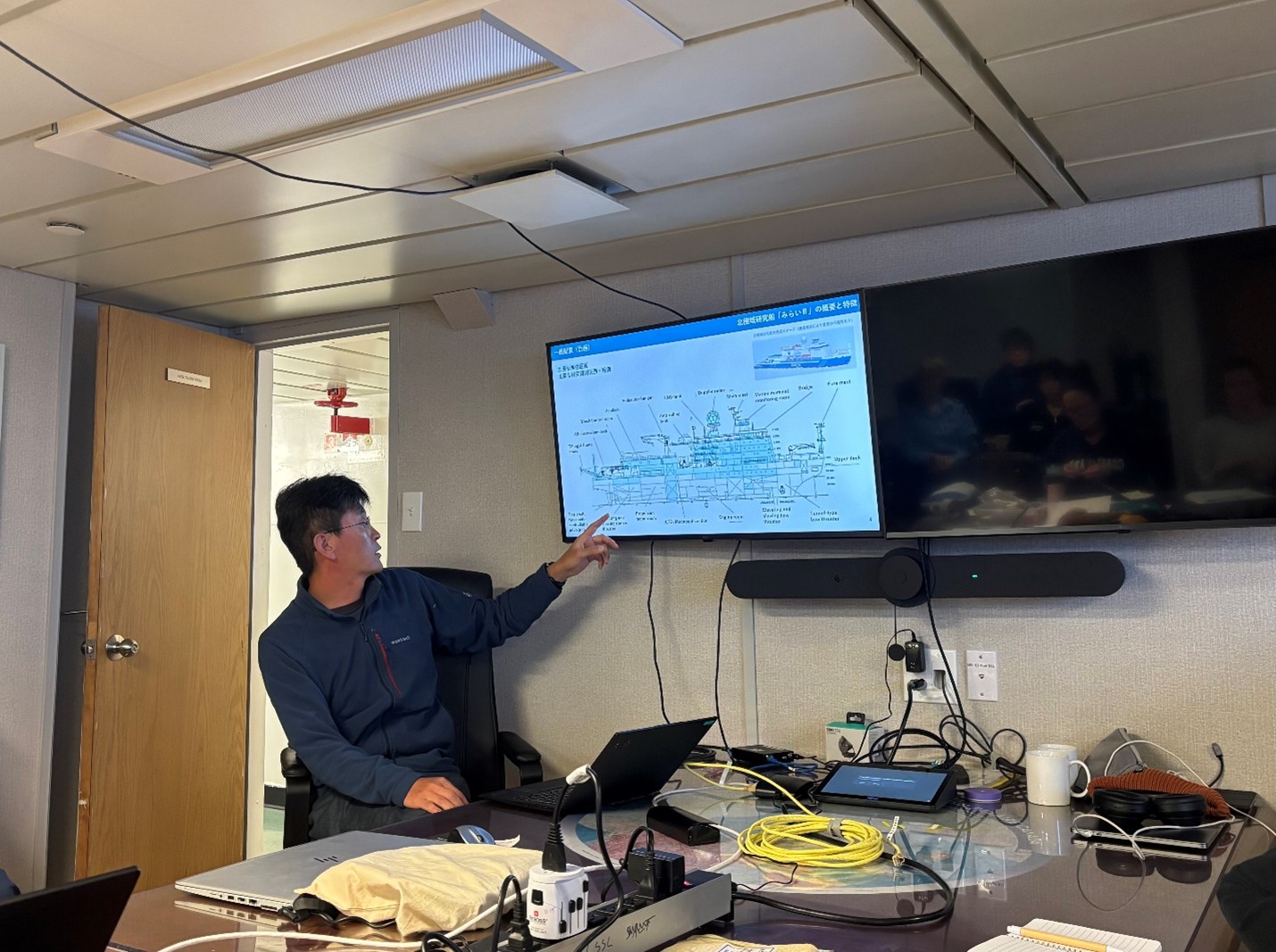 Photo 5: Michiharu Shibata giving a presentation about Mirai II, Japan’s first Arctic research vessel with icebreaking capabilities, during the daily science meeting. 