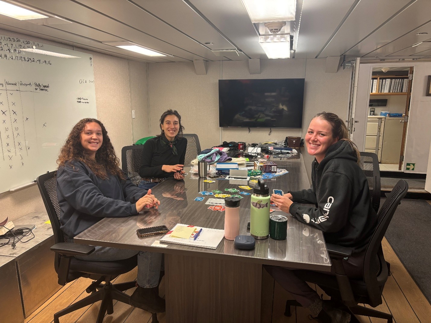 Photo 6: Members of the night watch (left to right: Collette Leclerc, Marguerite Larriere, Paige Hagel) playing a round of Dutch Blitz in between science stations. 