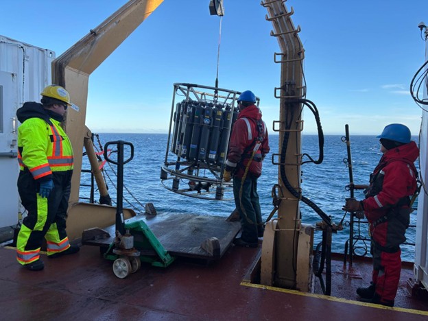 Dispatch27Photo1 Photo 1: (left to right) Deckhand Devon Fitzpatrick, Chris Clarke, and Céline Guéguen bringing the CTD rosette on deck.