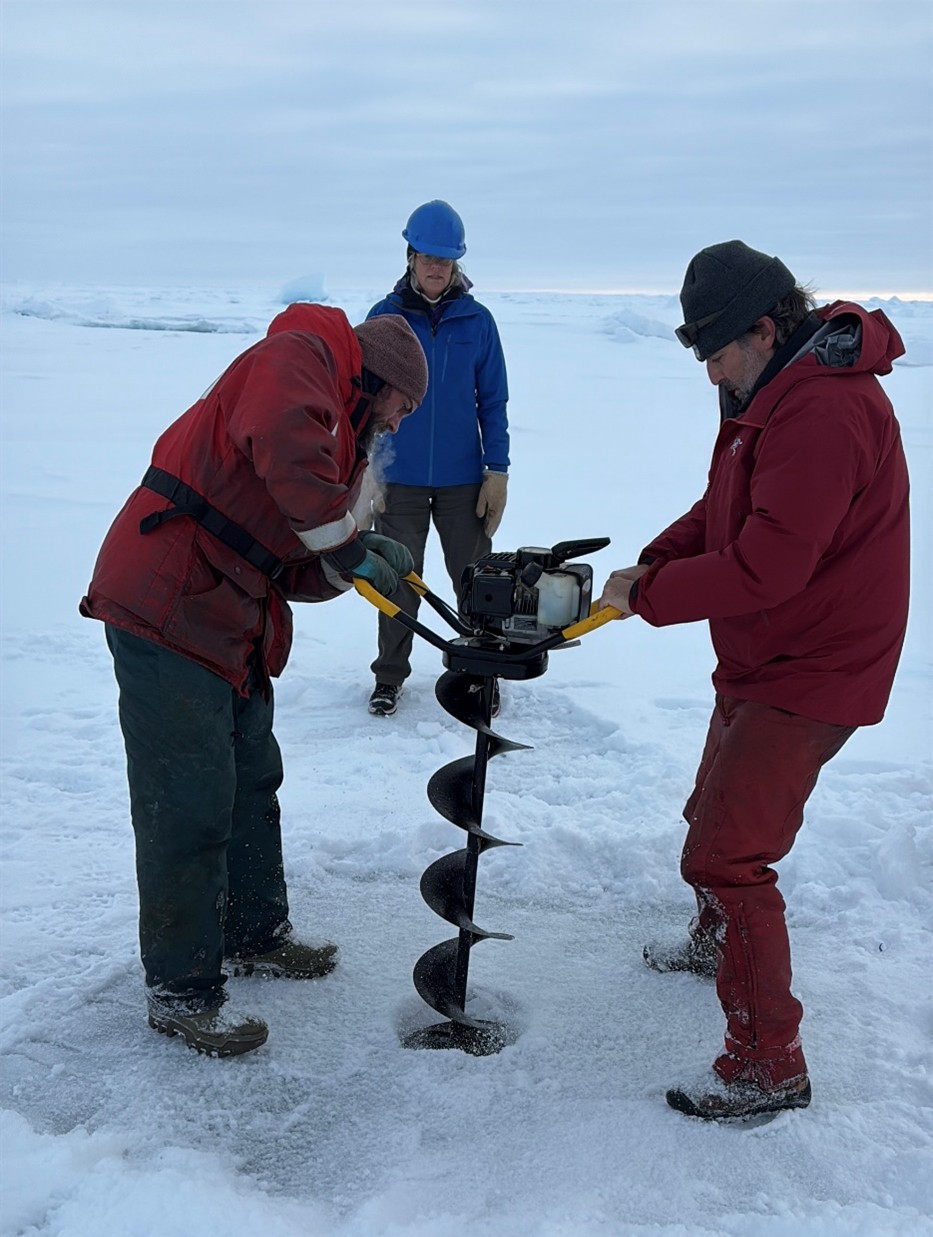 Picture8 Photo 6: Chris Clarke (left) and Paul Macoun (right) drilling a hole for the seasonal ice mass buoy while Sarah Zimmermann watches. Photo by Dominique Baker.