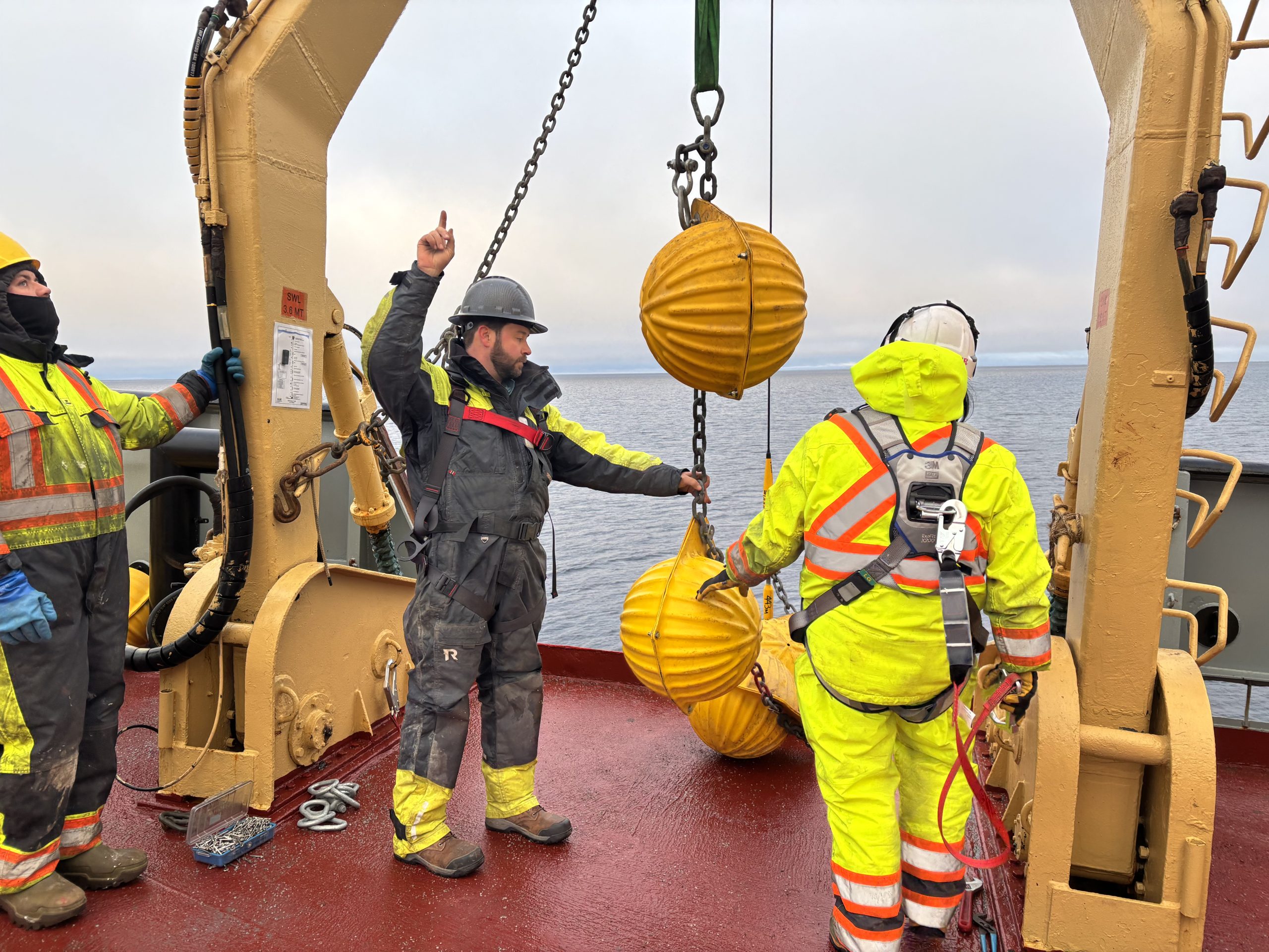 Chris Basque and bosun Ashley attaching glass buoyancy balls to the mooring wire. Photo by Jennifer Kosty. 
