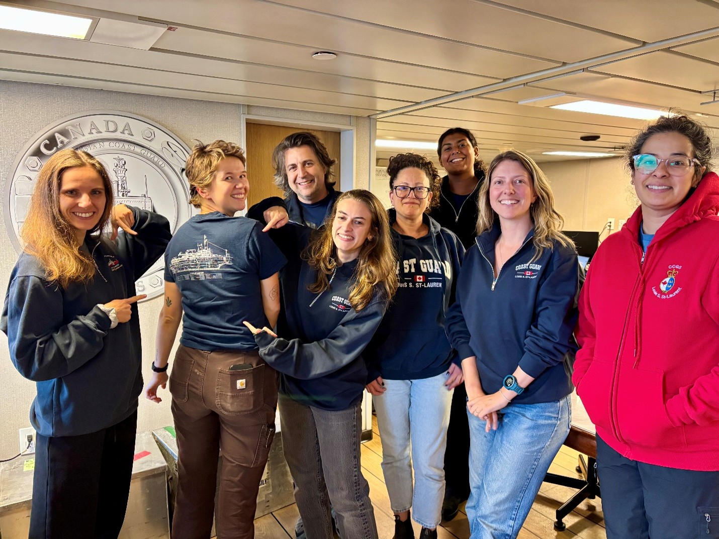 Members of the science team posing in their Louis merch! Shown here are (left to right) Jennifer Kosty, Chloe Immonen, Paul Macoun, Mackenzie Mueller, Sarah-Ann Quesnel, Lauren Bannerman-Maxwell, Monika Loevenmark, and Francesca Loro. Photo by Celine Gueguen. 