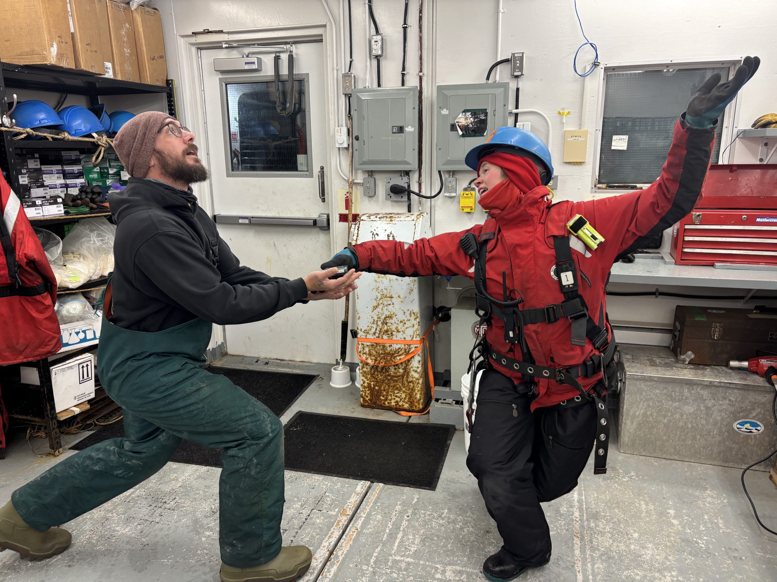 The ceremonial pager handoff from day shift watch leader Chloe Immonen (right) to night shift leader Chris Clarke (left). Photo by Jennifer Kosty. 