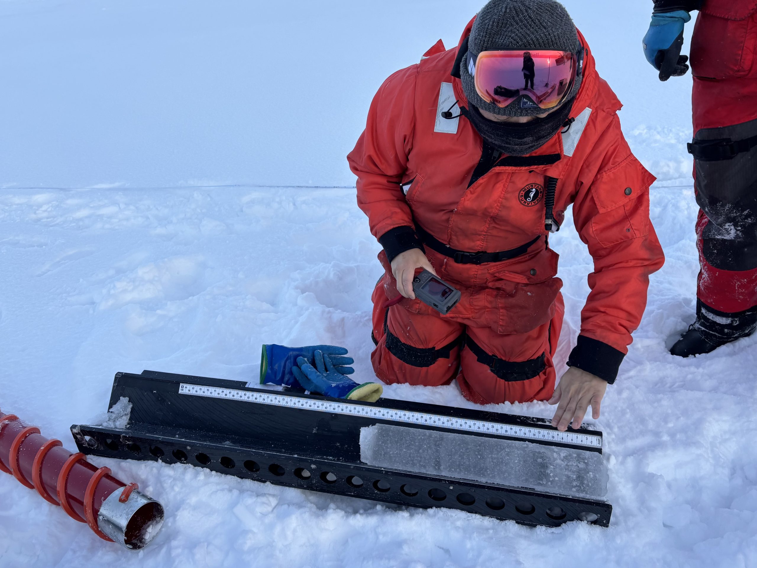 Kazu Tateyama examining a freshly collected ice core. Photo by Jennifer Kosty. 