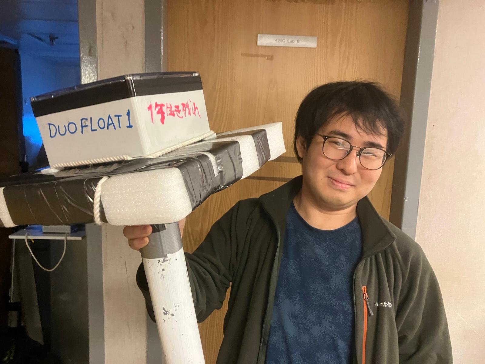 Koya Sato posing with the wave sensor that he helped develop. Photo by Takuji Waseda. 