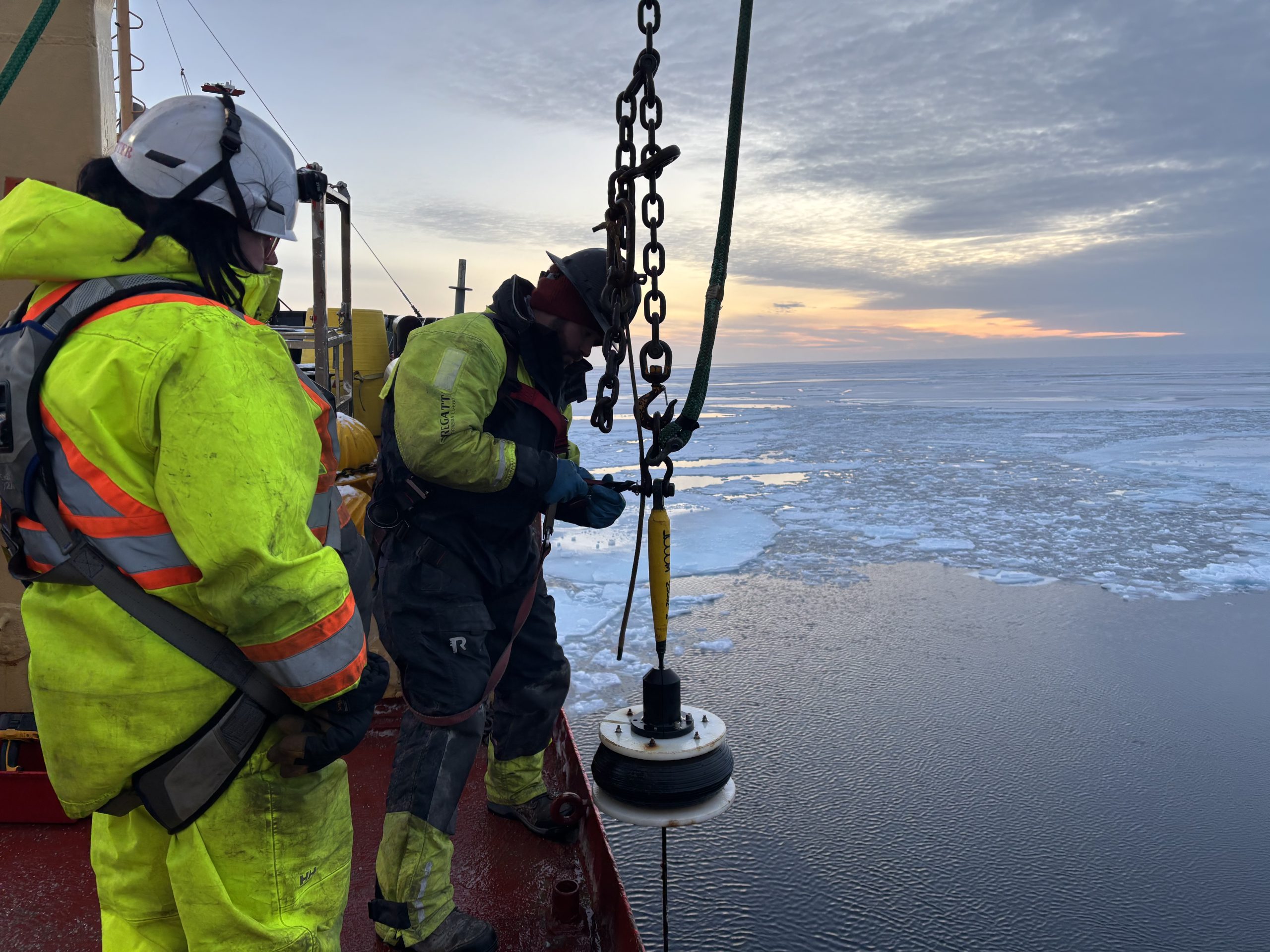 Chris Basque (right) and bosun Ashley (left) preparing to reel in the first segment of mooring wire. Photo by Jennifer Kosty. 