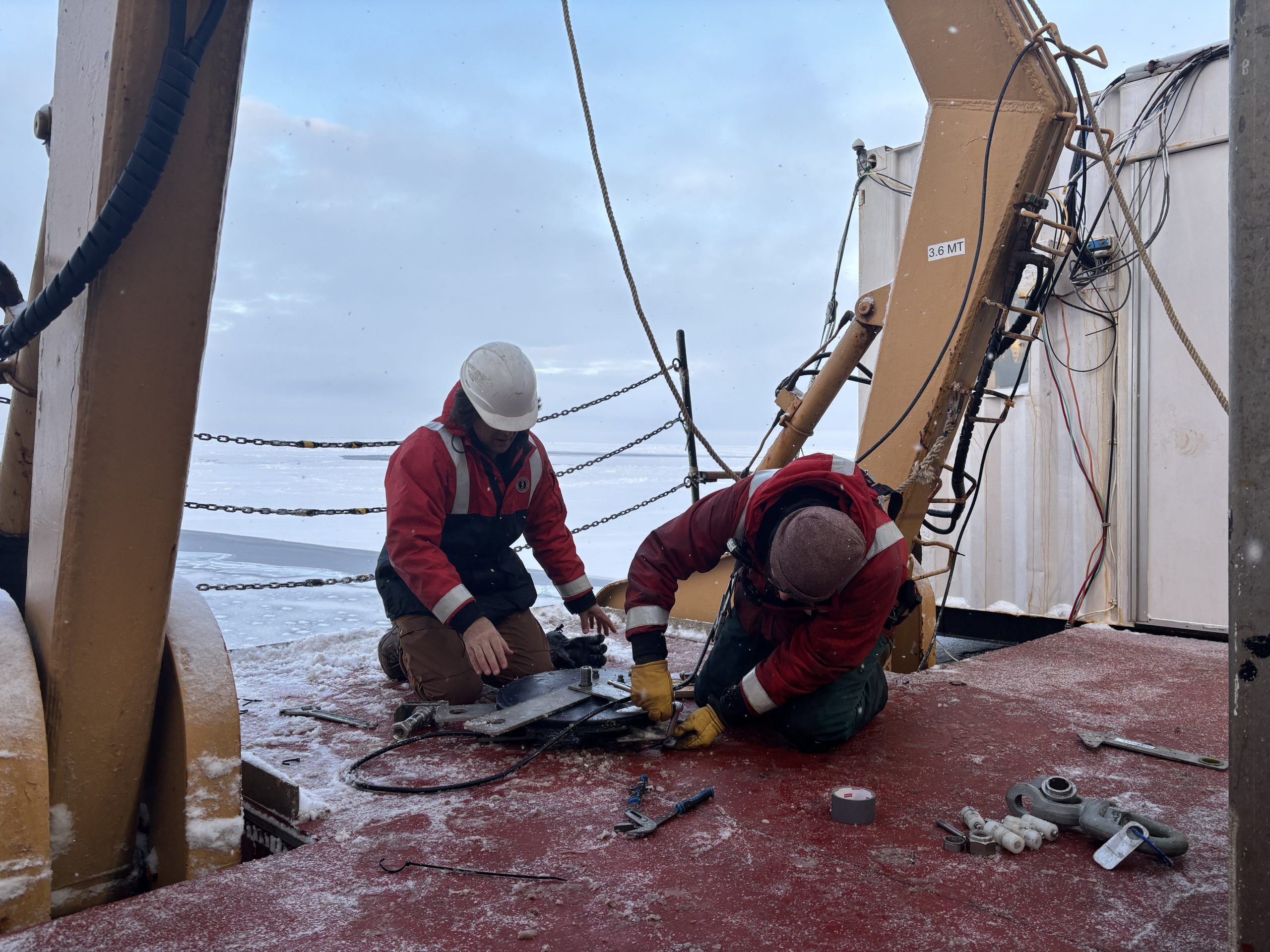 (left) Paul Macoun and (right) Chris Clarke disassembling the rosette wire block. Photo by Jennifer Kosty.