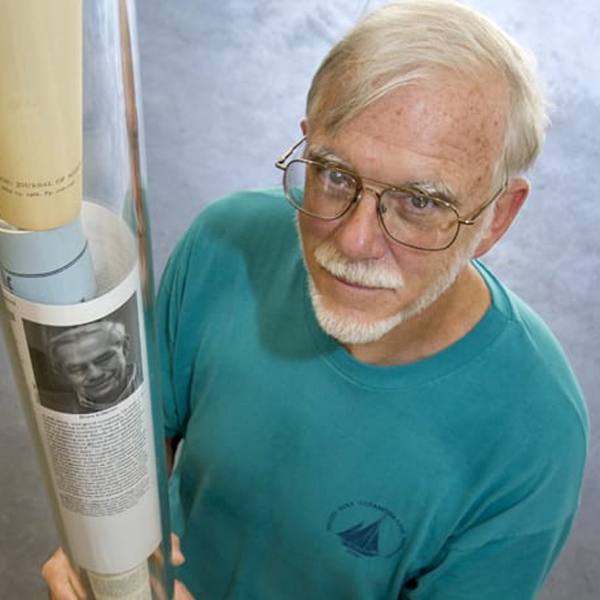 Jim Valdes stands holding a glass deep drifter and looks up at the camera above.