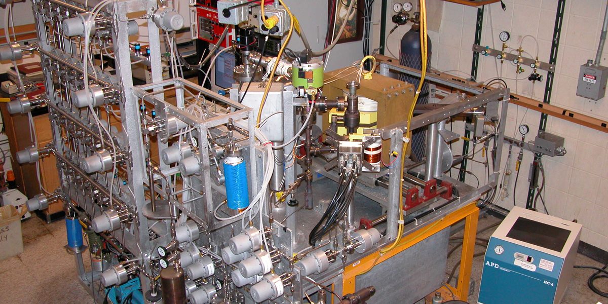 <strong>Helium Isotope and Tritium Measurement Mass Spectrometer System (MS1)</strong><br />
Our workhorse helium isotope and tritium measurement mass spectrometer system (MS1). This instrument was first designed and built in 1975, and has evolved, grown, and been modernized over the years. It is fully automated and runs 24/7. The larger stainless steel cylinders near the bottom/center of the picture are the cryogenic traps that are used to transfer and purify He and Ne. The magnetic sector mass spectrometer (middle, right) analyzes the helium isotopes, while the QMS (lower right) previews samples and measures He and Ne. The automanifold (left) allows the "mounting" of up to 32 samples for measurement and unattended operation.
