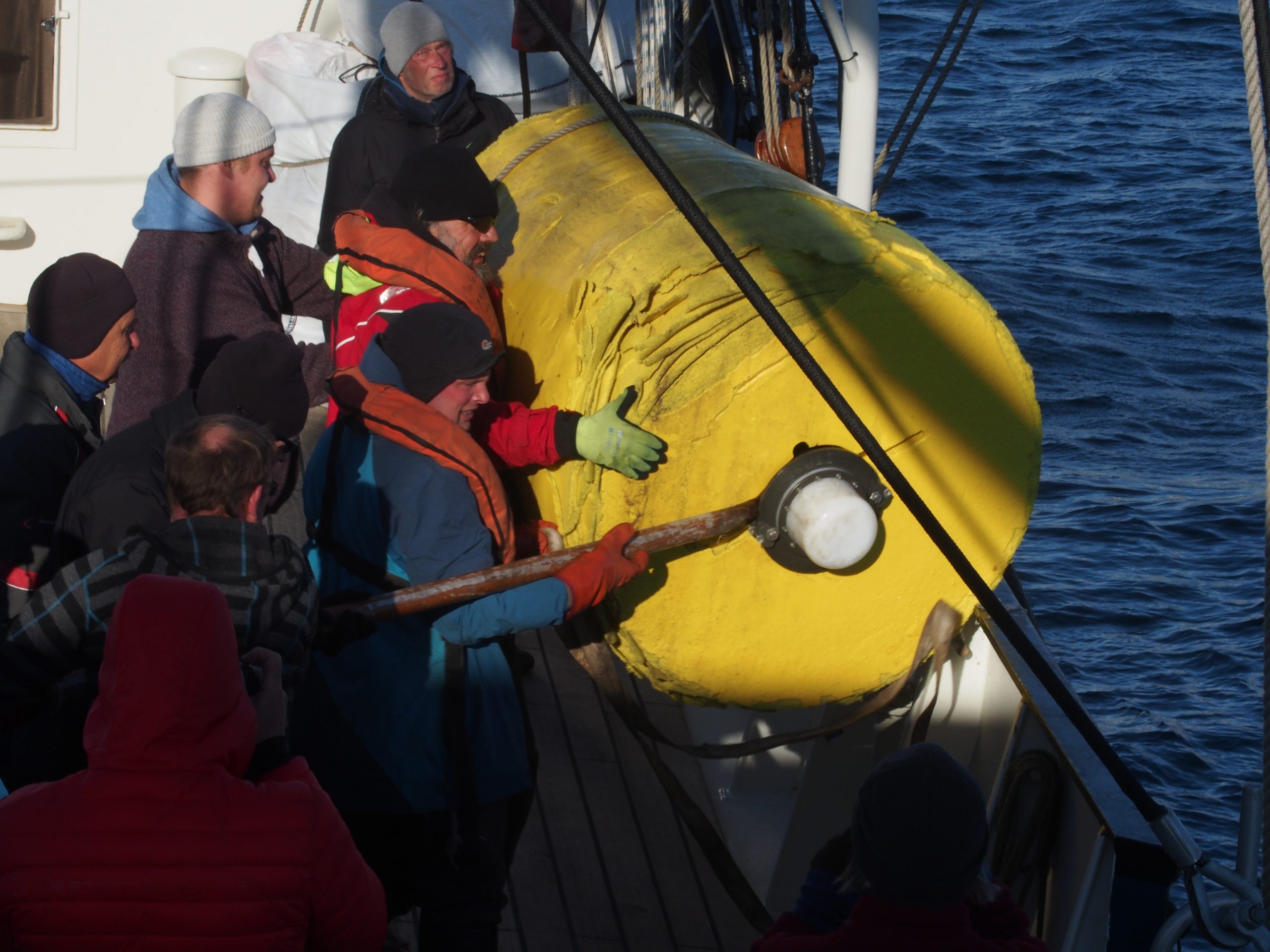 The surface package is hauled onboard the sailing vessel.