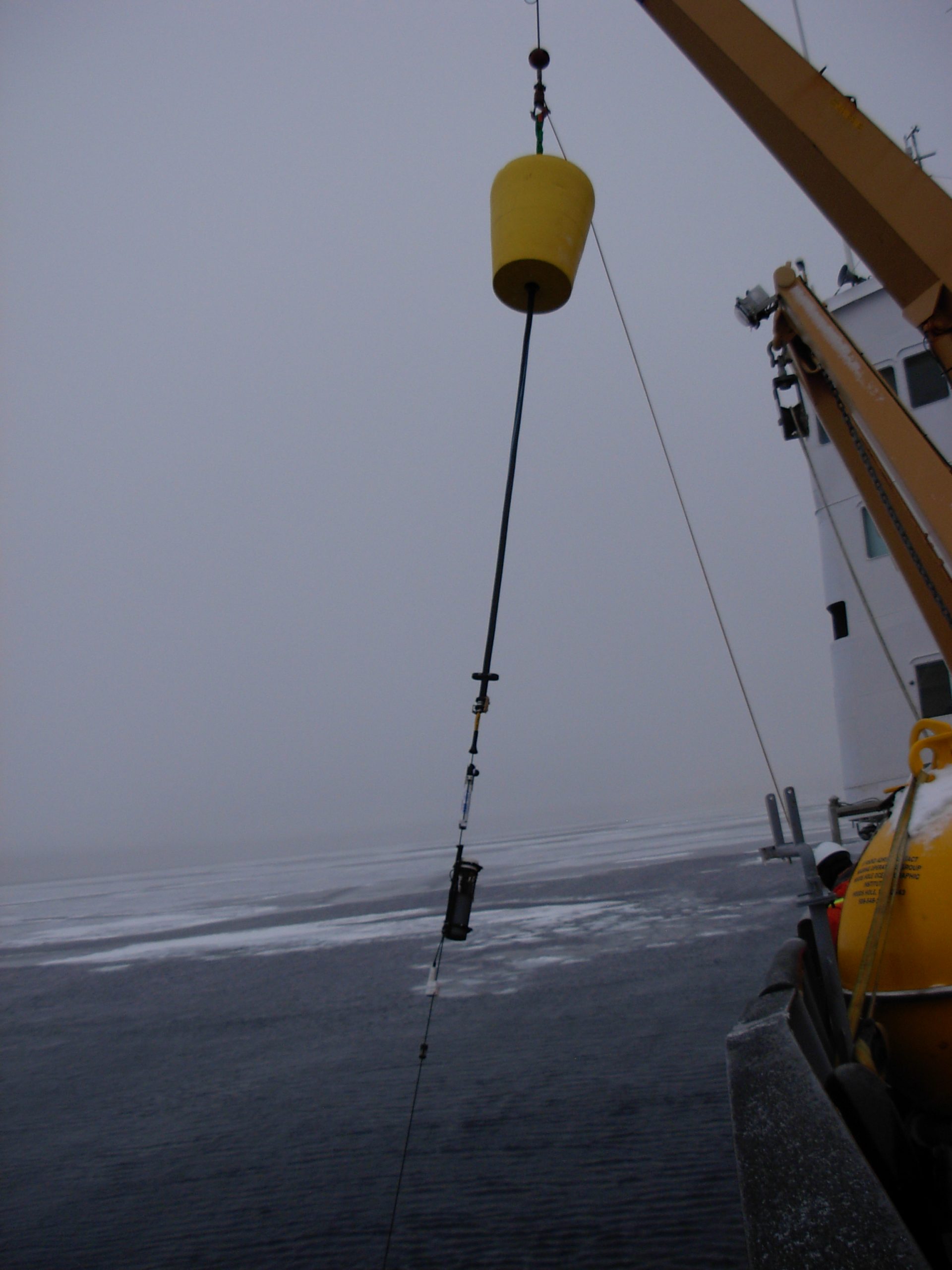 Surface package and SAMI attached to the wire, the complete mooring is lowered using the ship’s crane. (Photo by Rick Krishfield)