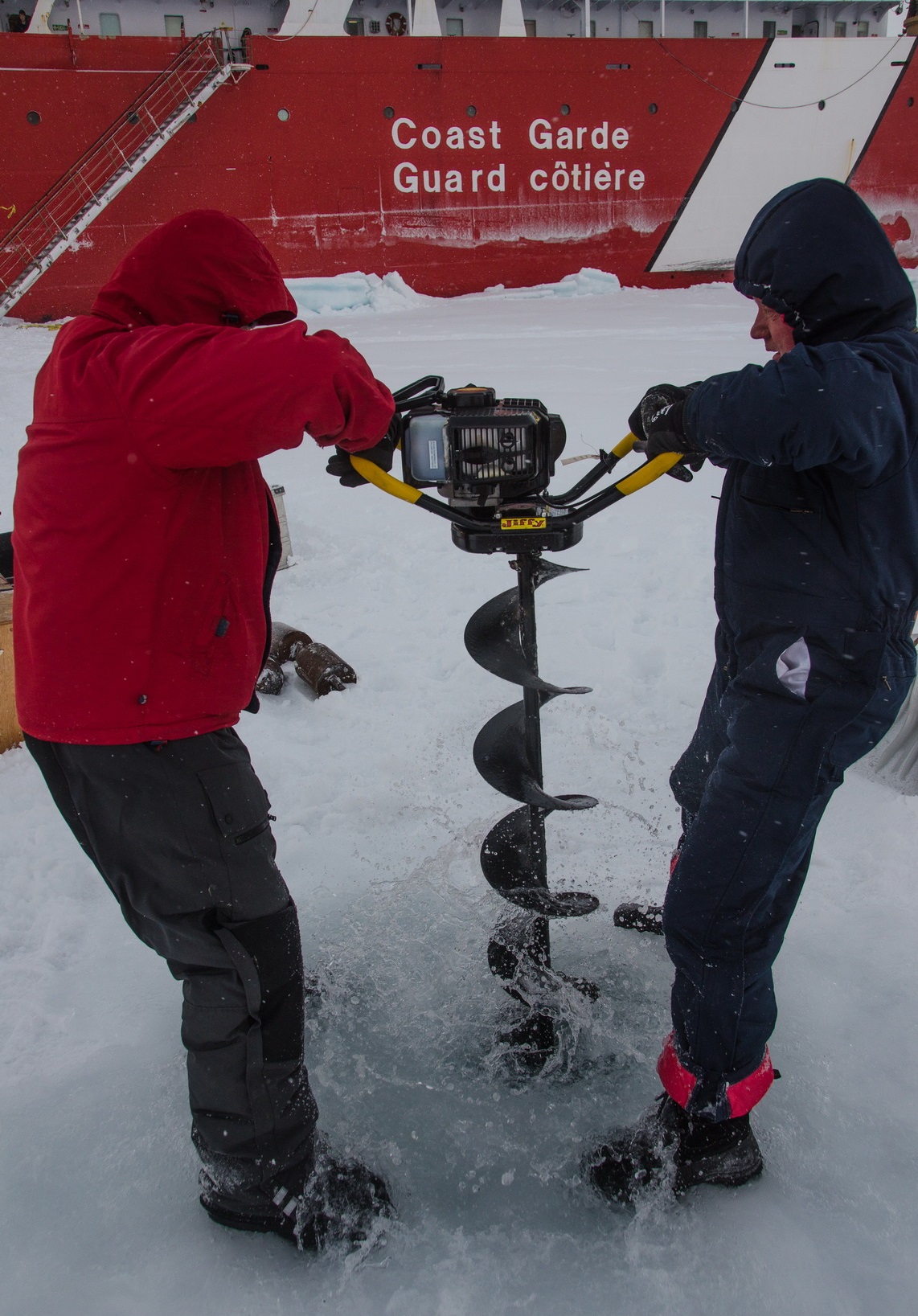 Jeff O’Brien and Andrey Proshutinsky have augered through the sea ice and reached the seawater.  (Photo by Gary Morgan)