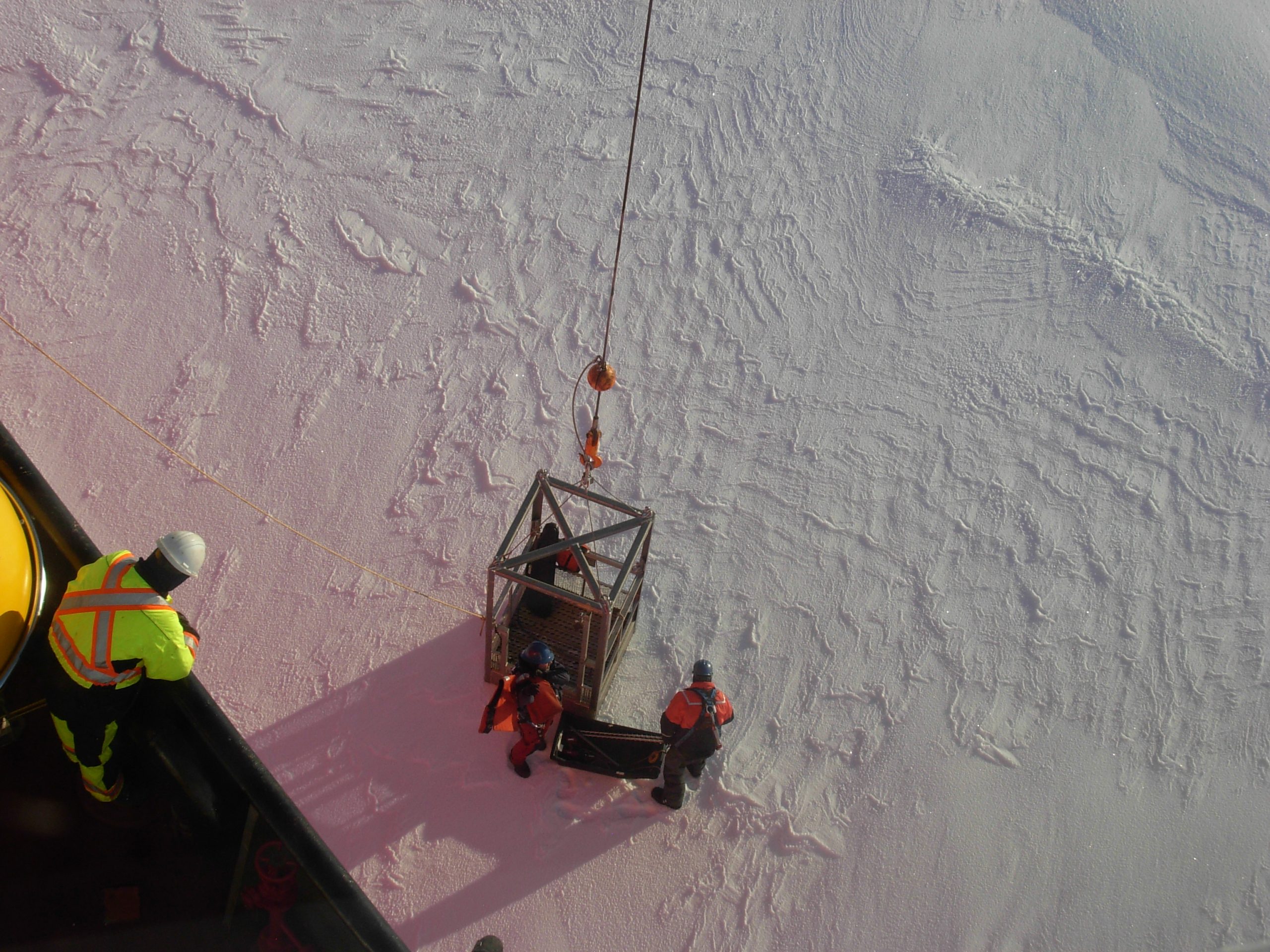 Jeff O’Brien and Cory Beatty are lowered to the ice in the manbasket to perform an ice survey for deployment of ITP 107. (Photo by Rick Krishfield)