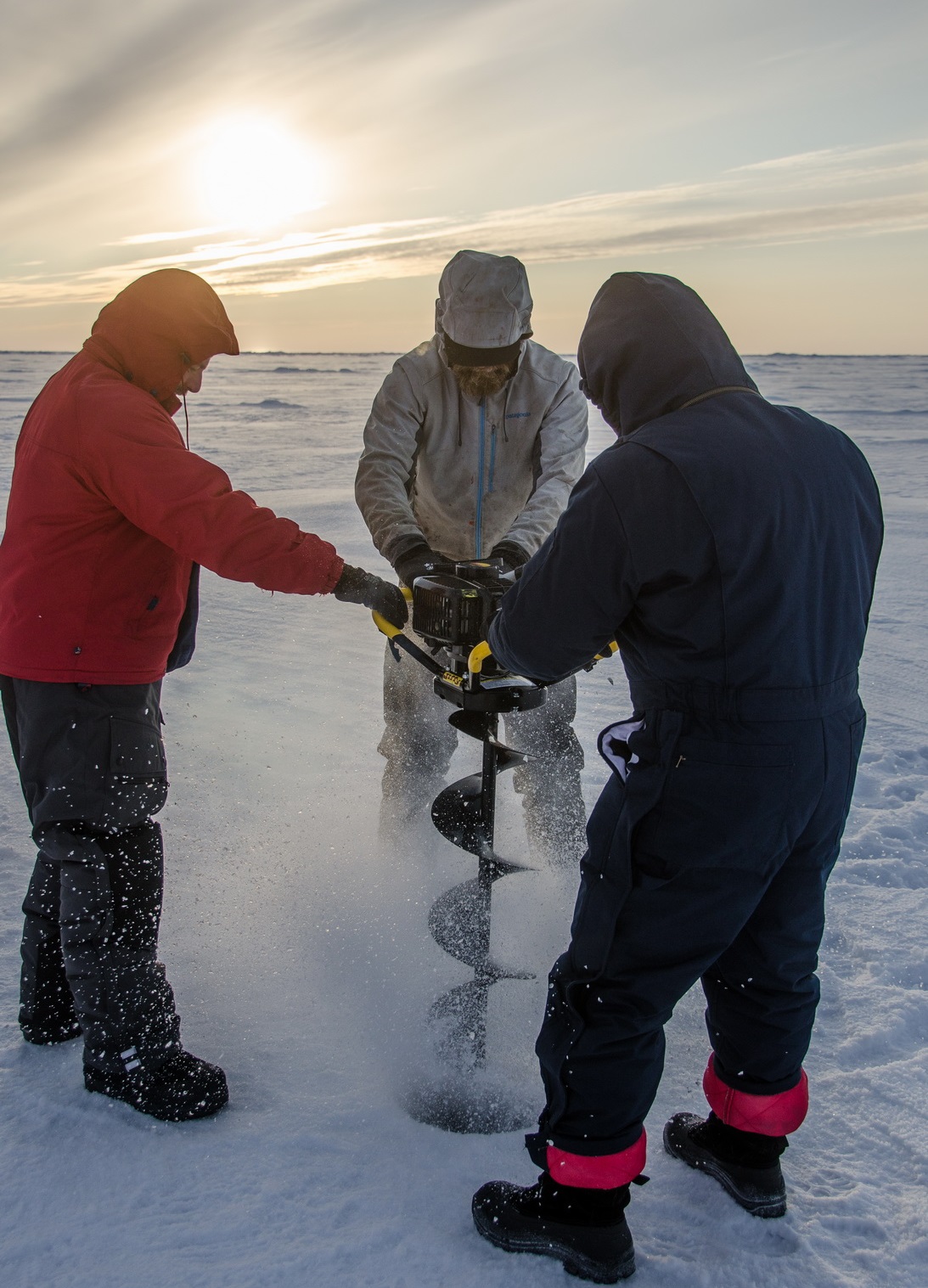 Jeff O’Brien steadies ice auger while Josh Mitchell and Andrey Proshutinsky bore through 0.5 m thick ice floe for ITP deployment. (Photo by Gary Morgan)