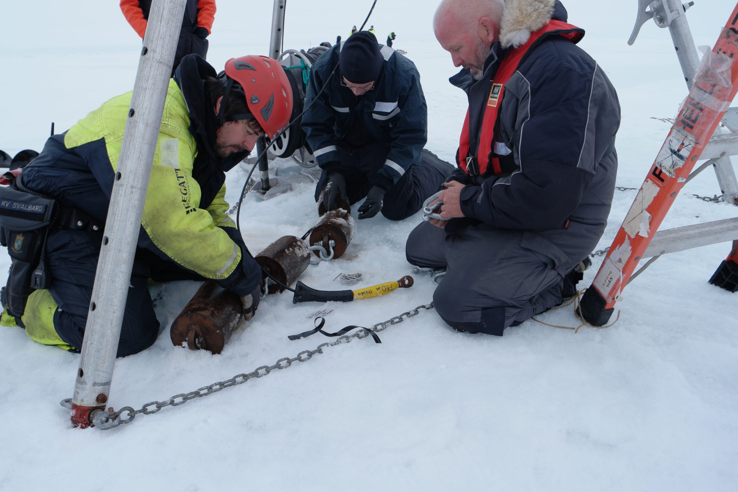 Nico Llanos, Peter Worcester and Jim Ryder rig the ITP anchor consisting of several steel weights prior to deployment.  (Photo by Hanne Sagen)