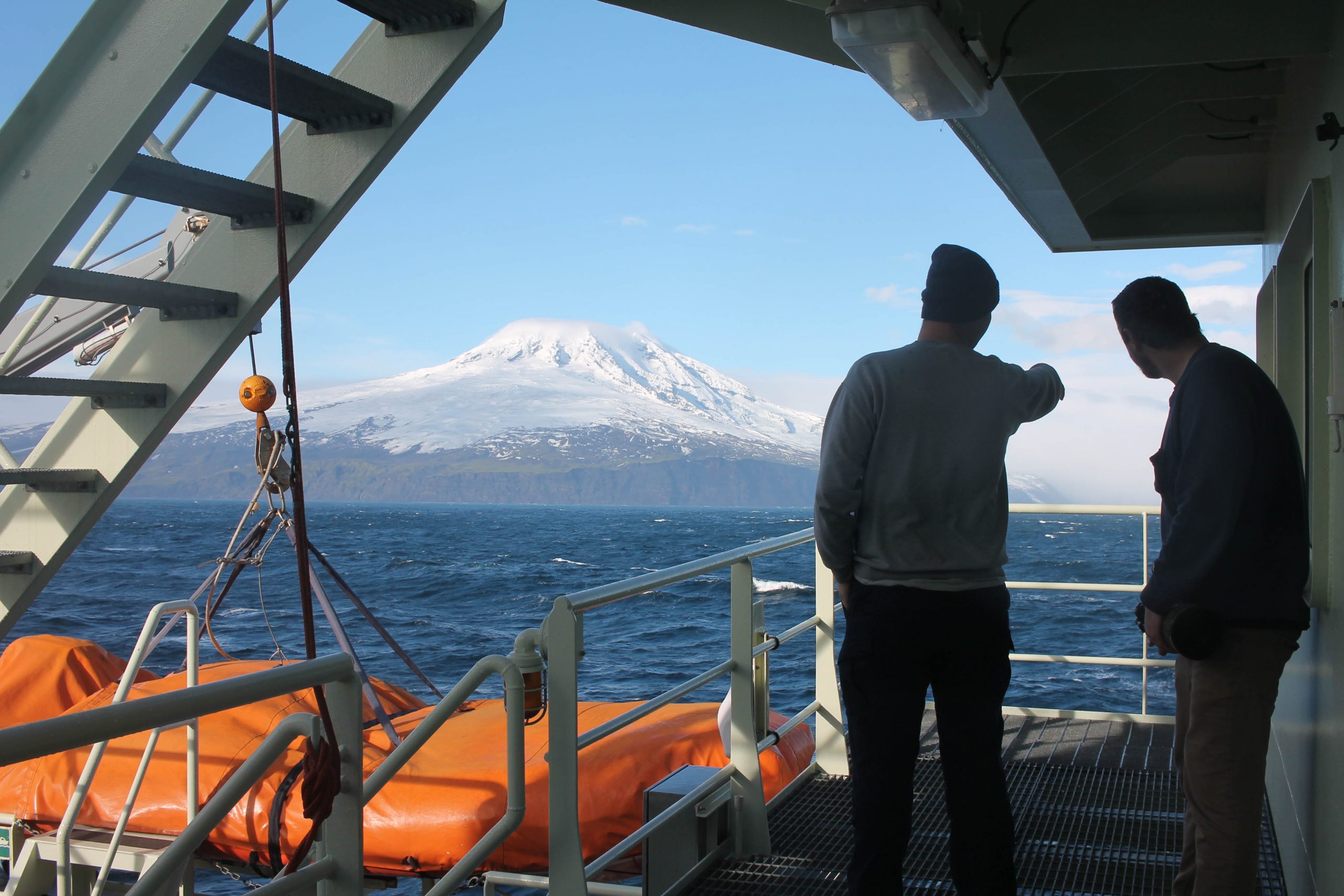 Third mate Kris Young and second mate Chris Cudney look out over Jan Mayen Third mate Kris Young and second mate Chris Cudney look out over Jan Mayen. Photo by Hannah Chanatry.