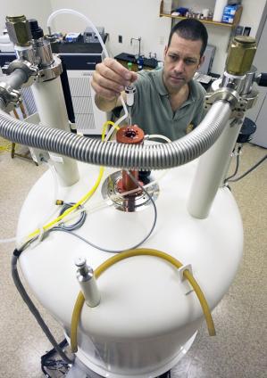 Research Specialist Carl Johnson introduces a sample of dissolved organic matter into the high field magnet of the NMR spectrometer.